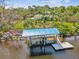 Scenic waterfront boat lift with a covered platform, perfect for protecting your boat at 5903 Cachette De Riviera Ct, New Port Richey, FL 34655