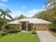 Beautifully landscaped home featuring a well-maintained lawn, mature trees, and a welcoming entrance at 5903 Cachette De Riviera Ct, New Port Richey, FL 34655