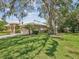 Home with manicured lawn, mature trees, and lush landscaping enhancing its curb appeal at 5903 Cachette De Riviera Ct, New Port Richey, FL 34655