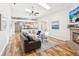 Open living room featuring wood floors, skylights, fireplace, and access to patio at 5903 Cachette De Riviera Ct, New Port Richey, FL 34655