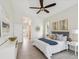 Bright bedroom with a ceiling fan, ensuite bathroom with a tub and decorative artwork at 5903 Cachette De Riviera Ct, New Port Richey, FL 34655