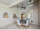 Covered outdoor living area with a circular dining table, ceiling fan and ample natural light at 5903 Cachette De Riviera Ct, New Port Richey, FL 34655