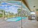Outdoor living is easy around this pool with outdoor kitchen, waterfront view and lush landscaping at 5903 Cachette De Riviera Ct, New Port Richey, FL 34655