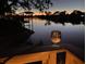 Relaxing waterfront scene with a sunset view and a glass of wine on the deck railing at 5903 Cachette De Riviera Ct, New Port Richey, FL 34655
