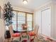 Bright breakfast nook with a glass table, woven chairs with orange cushions, and sunlit windows at 6012 28Th W St, Bradenton, FL 34207