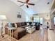 Cozy living room with vaulted ceilings, ceiling fan, plush sectional sofa, and sliding glass doors to the lanai at 6012 28Th W St, Bradenton, FL 34207