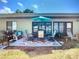Cozy patio setup with grill, bench, table, and chairs under a bright blue sky at 6012 28Th W St, Bradenton, FL 34207
