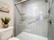 Modern shower with glass doors and tiled walls, and a decorative plant to complete the space at 6012 28Th W St, Bradenton, FL 34207