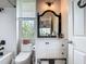 Well-lit bathroom boasts a walk-in shower, dark fixtures, and white cabinets and countertop at 9712 Little Gasparilla Is, Boca Grande, FL 33921