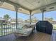 Covered patio with canal view, lounge chair, and grill at 9712 Little Gasparilla Is, Boca Grande, FL 33921