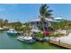 Waterfront home with a dock, boat lift, and lush tropical landscaping on a canal at 9712 Little Gasparilla Is, Boca Grande, FL 33921