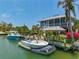 Waterfront property with dock and canal featuring lush landscaping and a covered seating area at 9712 Little Gasparilla Is, Boca Grande, FL 33921