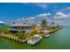 Waterfront home featuring a metal roof, white trim, boat dock and lush landscaping at 9712 Little Gasparilla Is, Boca Grande, FL 33921