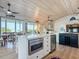 Bright kitchen with stainless appliances, island with microwave, and beverage fridge at 9712 Little Gasparilla Is, Boca Grande, FL 33921