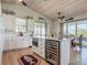 Open kitchen with large island with wine fridge, white cabinets, and stainless appliances at 9712 Little Gasparilla Is, Boca Grande, FL 33921