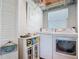 Bright laundry room with modern washer and dryer, shelving, and storage at 9712 Little Gasparilla Is, Boca Grande, FL 33921