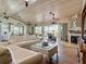 Bright living room boasts a fireplace, white couches, ceiling fans, and sliding doors to the outdoor porch at 9712 Little Gasparilla Is, Boca Grande, FL 33921