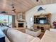 Bright living room with a fireplace and a TV, plus access to the outdoor deck at 9712 Little Gasparilla Is, Boca Grande, FL 33921