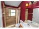 Red-walled bathroom featuring a walk-in shower, vanity, and mirror at 16804 Hawkridge Rd, Lithia, FL 33547