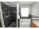 Nicely appointed bathroom with separate tub and shower, featuring dark accent tiles and glass block window at 16804 Hawkridge Rd, Lithia, FL 33547
