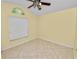 Cozy bedroom with tile floor, large window with blinds, and cream painted walls at 16804 Hawkridge Rd, Lithia, FL 33547