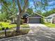 Inviting home featuring a well-maintained lawn, mature trees, and a two-car garage, perfect for Gathering living at 16804 Hawkridge Rd, Lithia, FL 33547