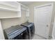 Well-equipped laundry room with stainless steel washer and dryer, plus ample built-in shelving and storage at 16804 Hawkridge Rd, Lithia, FL 33547