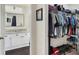 Bathroom next to walk-in closet that includes a vanity with granite countertop, a mirror, and shelving for storage at 18001 Richmond Place Dr # 337, Tampa, FL 33647