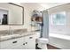 Bright bathroom featuring a vanity with marble countertop, storage shelves and shower at 18001 Richmond Place Dr # 337, Tampa, FL 33647