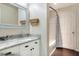 Bathroom featuring a white vanity with a granite countertop, framed mirror, and shower with patterned curtain at 18001 Richmond Place Dr # 337, Tampa, FL 33647