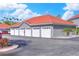 Garage building featuring a row of garages with white doors, a red tile roof, and gray walls at 18001 Richmond Place Dr # 337, Tampa, FL 33647