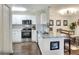 Modern kitchen with white cabinets, granite countertops, and stainless steel appliances open to living area at 18001 Richmond Place Dr # 337, Tampa, FL 33647