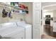 Laundry room with white washer and dryer, wire shelving, and an open doorway leading to the kitchen at 18001 Richmond Place Dr # 337, Tampa, FL 33647