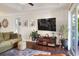 Warm living room featuring dark wood floors, a large TV, and sliding glass doors to a balcony at 18001 Richmond Place Dr # 337, Tampa, FL 33647