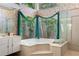 Bright bathroom with white cabinets, soaking tub with green curtains, and a walk-in shower, plants and nature views at 1909 Masters Way, Plant City, FL 33566