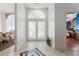 Bright foyer featuring decorative glass doors, tile flooring, and a glimpse of the dining and living spaces at 1909 Masters Way, Plant City, FL 33566
