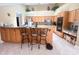 An eat-in kitchen features wood cabinets, granite countertops and a breakfast bar with seating for three at 1909 Masters Way, Plant City, FL 33566