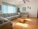 Bright living room with wood floors, a ceiling fan, a large sofa and views to the exterior at 1909 Masters Way, Plant City, FL 33566