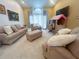 Comfortable living room with plush sofas, an ottoman, and natural light from a large window at 1909 Masters Way, Plant City, FL 33566