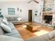 Spacious living room with vaulted ceilings, wood floors, a ceiling fan and a brick fireplace at 1909 Masters Way, Plant City, FL 33566
