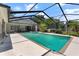 Relaxing screened-in pool area with a hot tub, palm trees and overlooking a green fairway at 1909 Masters Way, Plant City, FL 33566