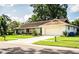 Traditional single-story home with a well-manicured lawn, mature trees, and an attached two-car garage at 2223 Wildwood Hollow Dr, Valrico, FL 33596