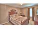 Bedroom with a wooden bed frame, matching furniture, and window creating a warm and inviting space at 2721 Walden Woods Dr, Plant City, FL 33566