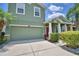 Charming two-story house boasting lush greenery, mature palms, and a painted green two-car garage door at 2721 Walden Woods Dr, Plant City, FL 33566
