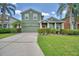 Inviting two-story home showcasing a green lawn, mature trees, and a red front door at 2721 Walden Woods Dr, Plant City, FL 33566
