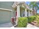 Classic two-story home with columns, lush plants, and a two-car garage, creating a welcoming entrance at 2721 Walden Woods Dr, Plant City, FL 33566