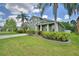 Lovely two-story home featuring a manicured green lawn, tall palm trees, and a welcoming front porch at 2721 Walden Woods Dr, Plant City, FL 33566