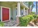 Inviting home exterior features a red front door, stone column bases, and lush landscaping at 2721 Walden Woods Dr, Plant City, FL 33566