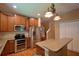 A kitchen featuring wooden cabinets, stainless steel appliances, and a bar area with pendant lighting at 2721 Walden Woods Dr, Plant City, FL 33566