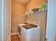 Laundry room with washer and dryer, neutral wall color, and wire rack shelving at 2721 Walden Woods Dr, Plant City, FL 33566